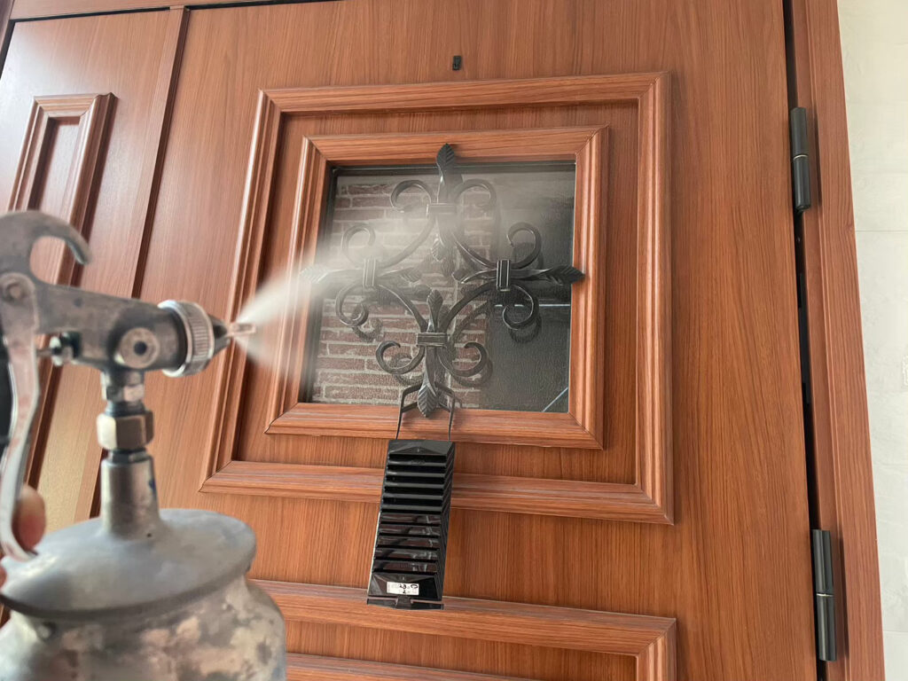 玄関扉部分に仕上げ材の光触媒プロテクトコーティング（クリスタルシーズンtg）を塗布します。