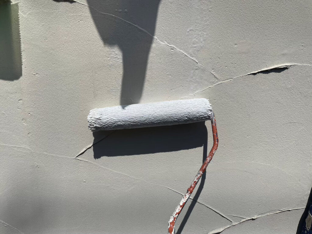 外塀下塗り施工中。