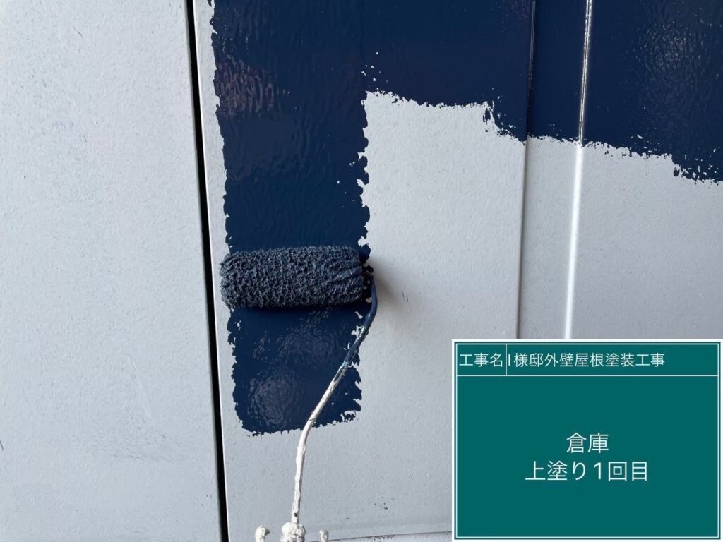 【物置 上塗り1回目】<br />
物置の上塗り1回目を行っています。サビ止めの下地の上から、高い耐候性を持つ仕上げ塗料をローラーやハケを使って丁寧に塗り進めていきます。