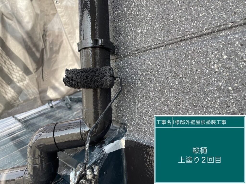 【配管・竪樋 上塗り2回目】<br />
竪樋や配管の上塗り2回目（仕上げ）を行っています。1回目が乾いた後にしっかりと塗り重ねることで、十分な塗膜の厚みを確保し、長期間にわたって素材を保護する高い耐久性と美しいツヤを出します。
