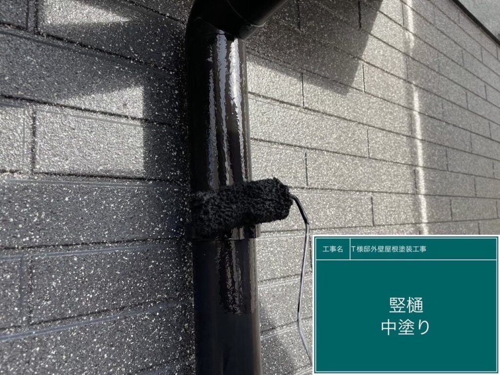 【配管・竪樋 中塗り】<br />
竪樋や各種配管の中塗りを行っています。紫外線や雨風の影響を受けやすい付帯部のため、細かい部分や見えにくい裏側まで、丁寧に均一な厚みで塗料を乗せていきます。