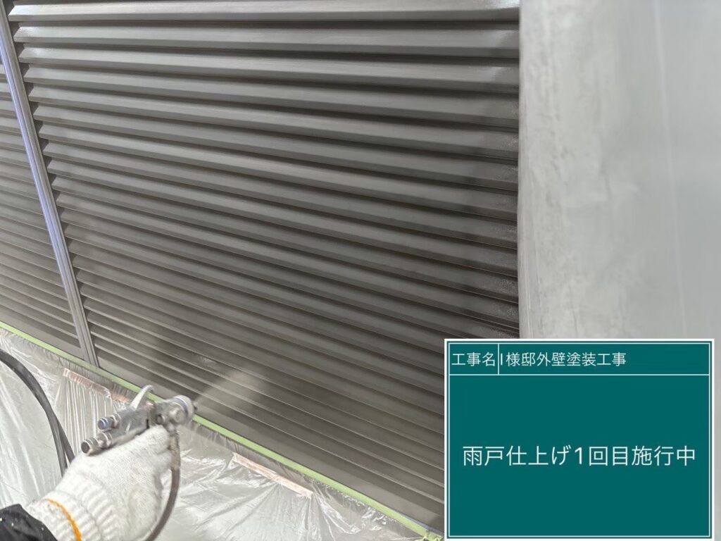 【雨戸 仕上げ1回目施工中】<br />
雨戸の仕上げ1回目を行っています。凹凸のある雨戸の形状に合わせて、吹き付け工法で細部まで均一な厚みになるよう丁寧に塗料を乗せていきます。<br />
