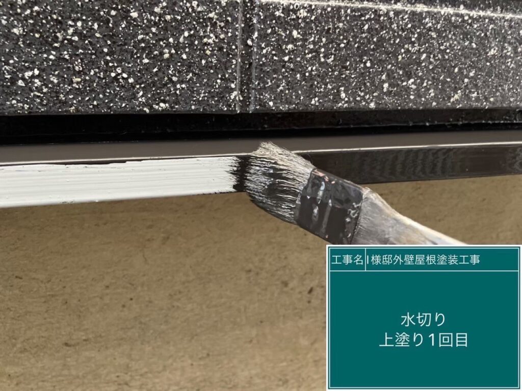 【水切り 上塗り1回目】<br />
水切りの上塗り1回目を行っています。サビ止めの下地の上から、美観と耐候性を高めるための仕上げ塗料を丁寧に塗り重ねていきます。