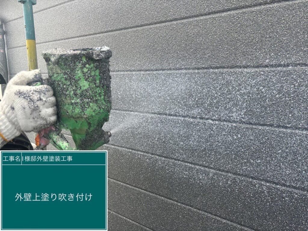 外壁の上塗り（仕上げ）を吹き付け工法で行っています。特殊な吹き付け技術を使用し、色や模様を立体的に、かつ均一な厚みで美しく乗せていきます。