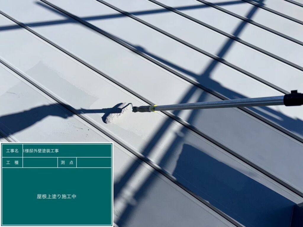 【屋根 ガルバリウム鋼板上塗り施工中】<br />
屋根リフォームの最終仕上げとなる上塗り（3回目の塗装）を行っています。中塗りと同じ高級塗料をもう一度重ねる「計3回塗り」を徹底し、メーカー規定の基準塗布量を完璧に守ることで、紫外線や過酷な太陽熱に何年も負けない強固な塗膜を形成します。<br />
