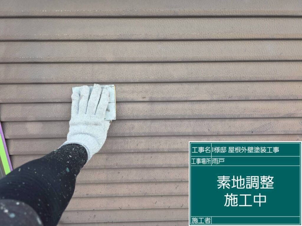 【雨戸 素地調整】<br />
雨戸の素地調整（ケレン作業）を行っています。表面の古い塗膜やサビ、汚れを落とすと同時に、全体に細かな傷をつける「目荒らし」をすることで、新しく塗る塗料の密着性を高める重要な下地処理です。<br />
