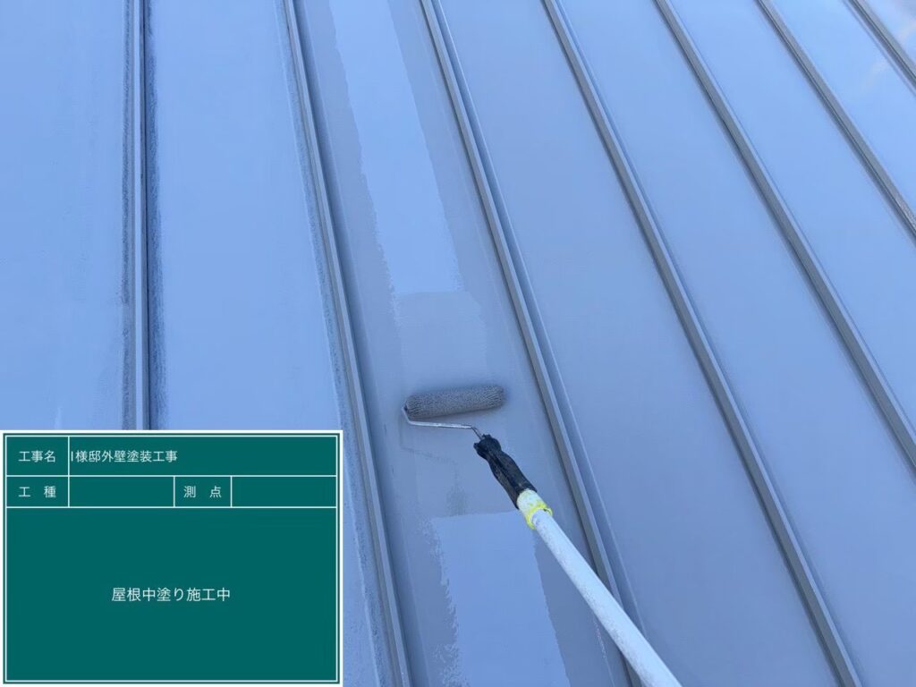 【屋根 ガルバリウム鋼板中塗り施工中】<br />
下塗りが完全に乾燥した後、中塗り（2回目の塗装）を進めていきます。優れた遮熱性と抜群の耐候性を持つ屋根専用の高級塗料を使用し、職人の手で均一な厚みになるよう、ローラーと刷毛を使い分けて隙間なく丁寧に塗り込んでいきます。<br />

