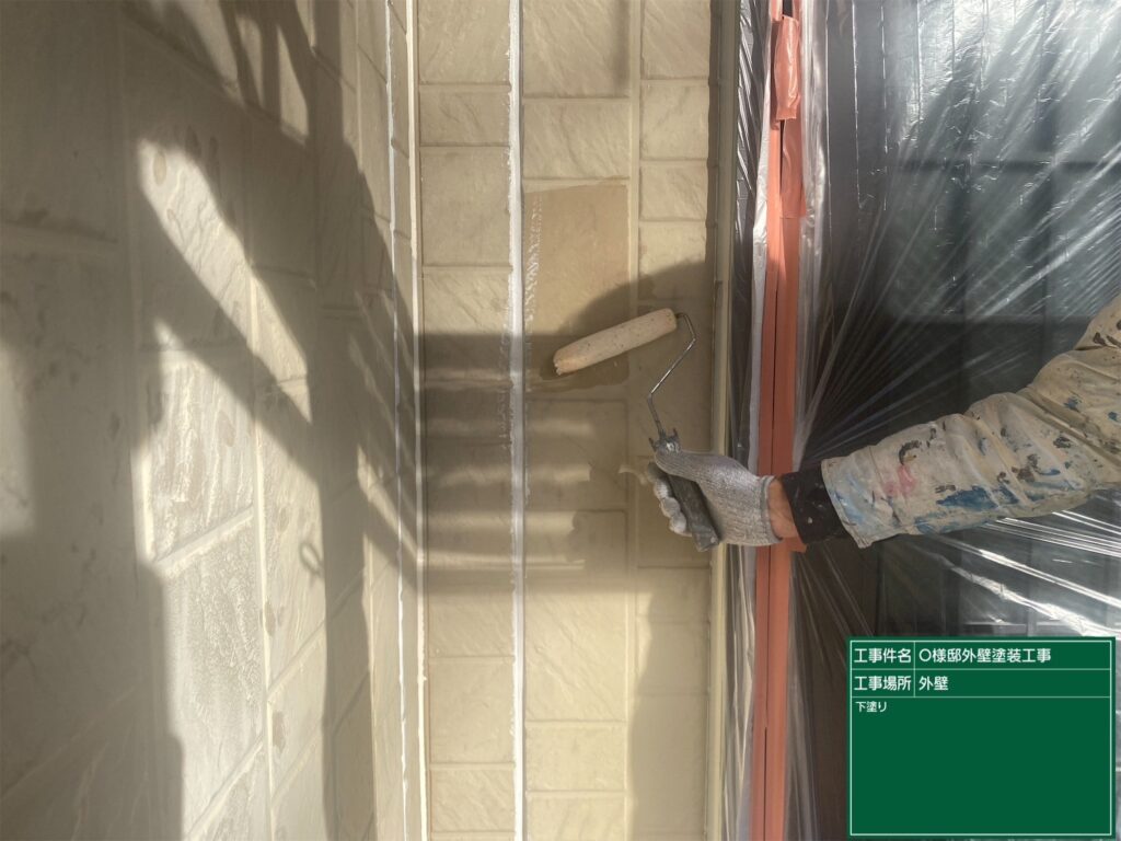 【外壁 下塗り施工中】<br />
外壁リフォームの第1ステップである下塗り（1回目の塗装）を行っています。傷んだ外壁材に下塗り材をたっぷりと染み込ませることで、これから塗り重ねる中塗り・上塗り塗料をガッチリと密着させるための極めて重要な土台作りです。