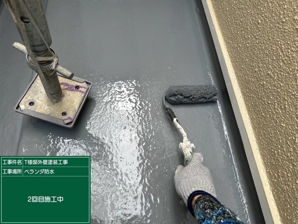 【ベランダ(バルコニー) 防水 上塗り】<br />
防水材の上塗り（防水層の形成2回目）を行っています。中塗りでできた層の上へ、さらに防水材を塗り重ねて十分な厚み（膜厚）を確保し、建物を雨漏りから長期間守るための強固で隙間のない防水層を完成させます。
