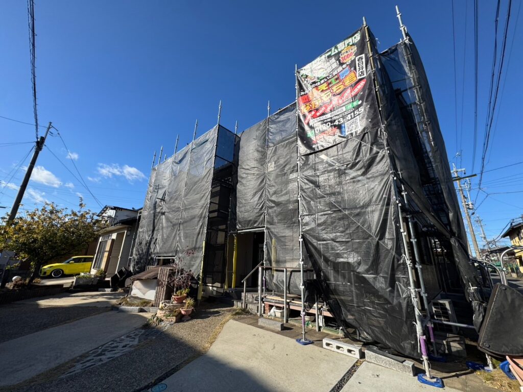 【足場設置・メッシュシート展開】<br />
職人が安全かつ精密な作業を行うための足場を組み立てました。近隣の皆様へ塗料や水が飛散するのを防ぐため、お家全体をしっかりとメッシュシートで囲い、配慮を徹底します。
