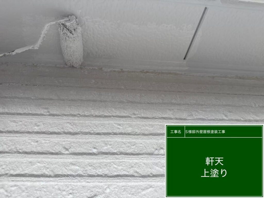  【軒天 仕上げ2回目 施工中】<br />
軒天の仕上げ2回目です。見上げの作業で光の当たり方が変わるため、ローラーの「継ぎ目（跡）」や塗り残しが出ないよう、熟練の職人が一定の圧力をかけながら真っ白に仕上げていきます。