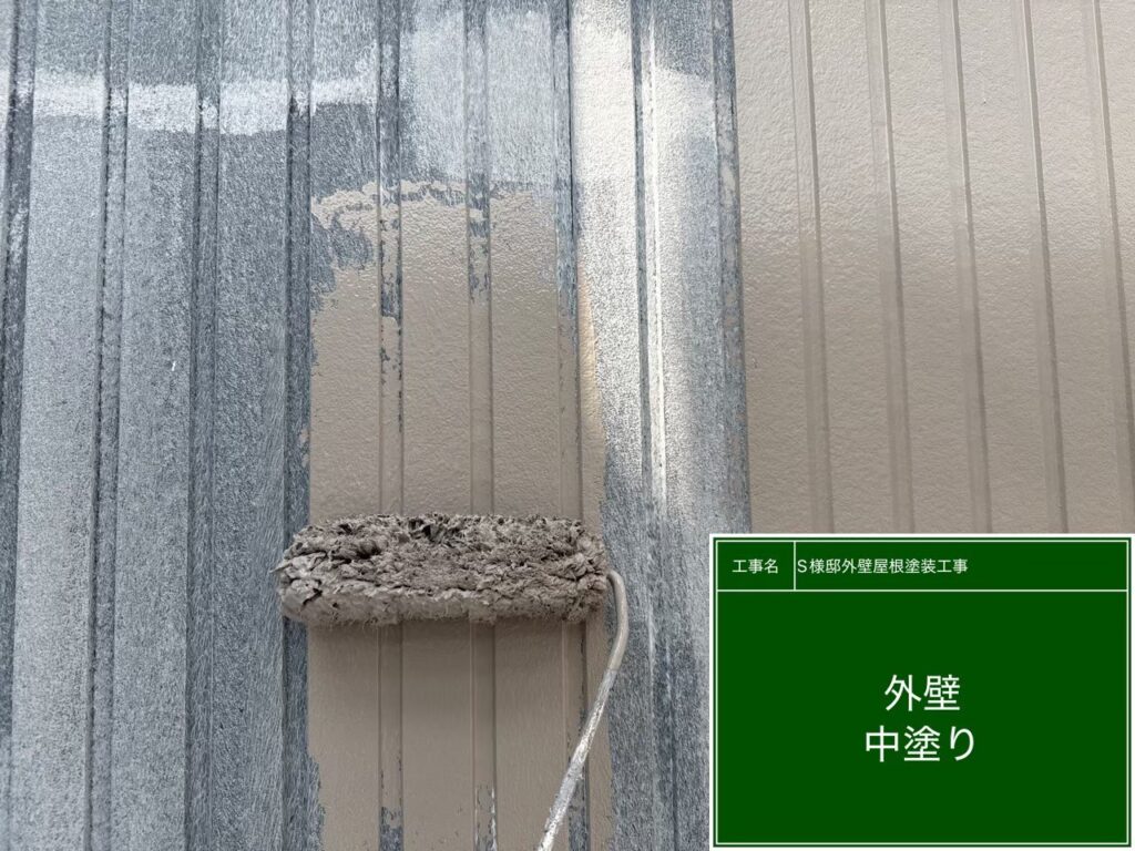 【外壁 ガルバリウム鋼板中塗り施工中】<br />
中塗り（2回目の塗装）を進めていきます。優れた遮熱性と抜群の耐候性を持つ外壁専用の高級塗料を使用し、職人の手で均一な厚みになるよう、ローラーと刷毛を使い分けて隙間なく丁寧に塗り込んでいきます。<br />
