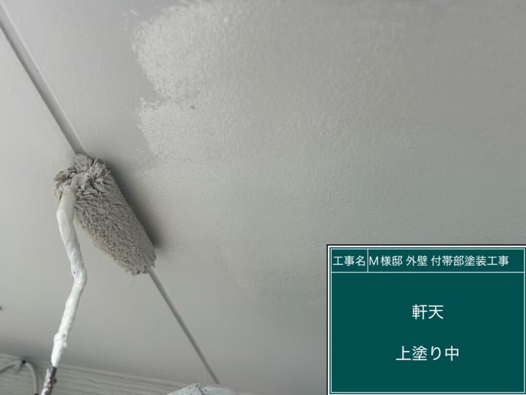【軒天 仕上げ2回目 施工中】<br />
軒天の仕上げ2回目です。見上げの作業で光の当たり方が変わるため、ローラーの「継ぎ目（跡）」や塗り残しが出ないよう、熟練の職人が一定の圧力をかけながら真っ白に仕上げていきます。<br />
