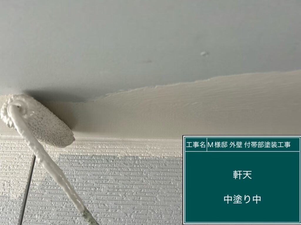 【軒天 仕上げ1回目 施工中】<br />
太陽光が当たらず湿気や雨気がこもりやすい軒天の塗装です。内部からの湿気を通す「透湿型（吸湿性）の専用防カビ塗料」を使用し、水分による塗膜の膨れや剥がれを根本から防ぐ下地を塗布しています。