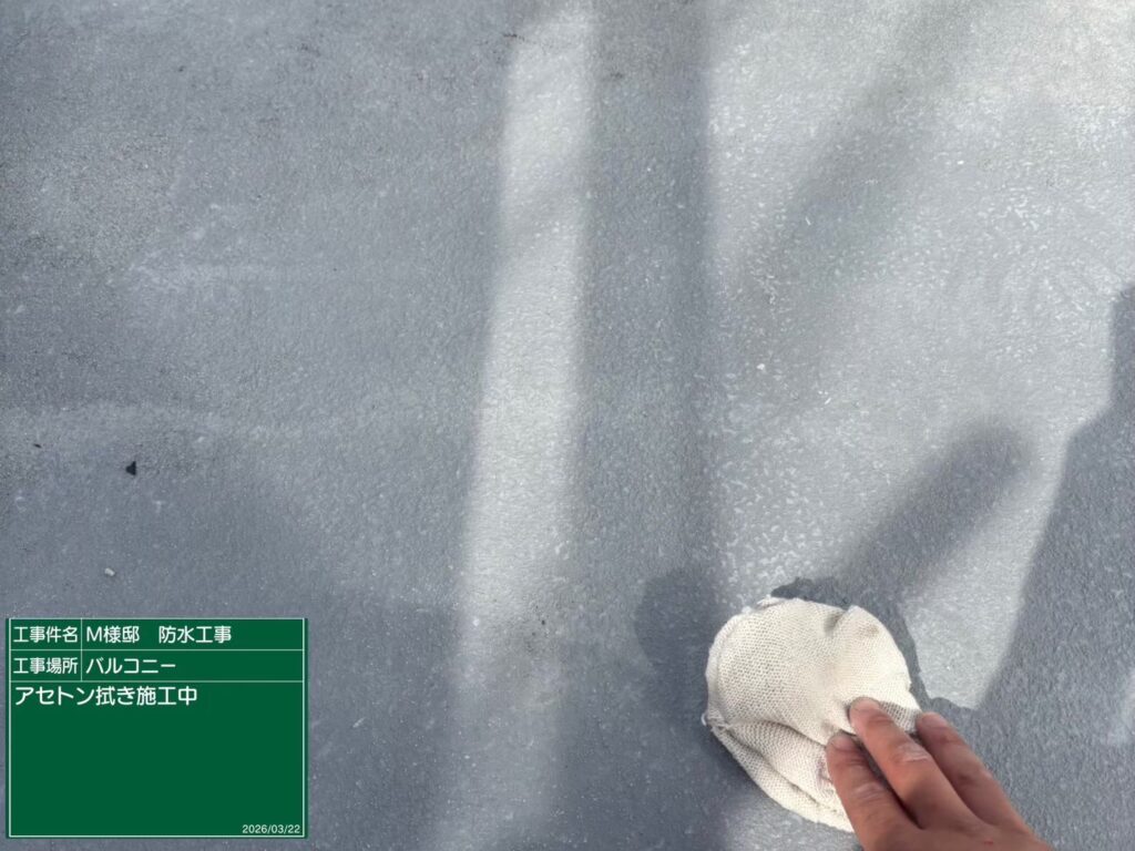 【FRP防水 ケレン（下地調整）中】<br />
ベランダ床面（FRP防水層）のケレン作業です。既存のトップコートの表面をアセトン等の専用溶剤で油分を完全に拭き取ります。この徹底的な脱脂と目荒らしが、新しい防水層の剥がれを完全に防ぎます。<br />
