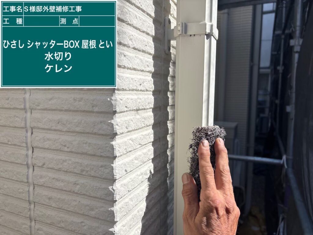 【竪樋 ケレン（下地調整）中】<br />
外壁に沿って走る竪樋のケレン作業です。雨樋は常に直射日光にさらされて素材が脆くなりやすいため、マジックロン等を使って素材を傷めない絶妙な力加減で汚れを落とし、密着性を高めます。<br />
