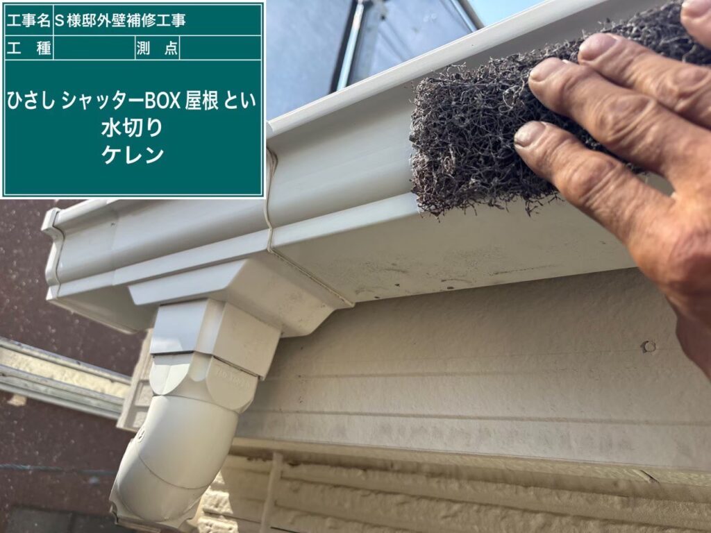 【軒樋 破風板ケレン（下地調整）中】<br />
軒樋の塗装前に、表面の「紫外線劣化」を起こした旧塗膜や頑固な汚れを削り落とすケレン作業です。あえて表面に微細な傷をつける（目荒らし）ことで、新しく塗る塗料の「付着性（食いつき）」を劇的に高めるプロの必須工程です。<br />
