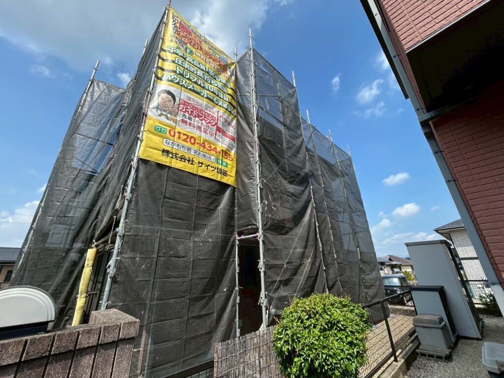 【足場設置・メッシュシート展開】<br />
職人が安全かつ精密な作業を行うための足場を組み立てました。近隣の皆様へ塗料や水が飛散するのを防ぐため、お家全体をしっかりとメッシュシートで囲い、配慮を徹底します。<br />
